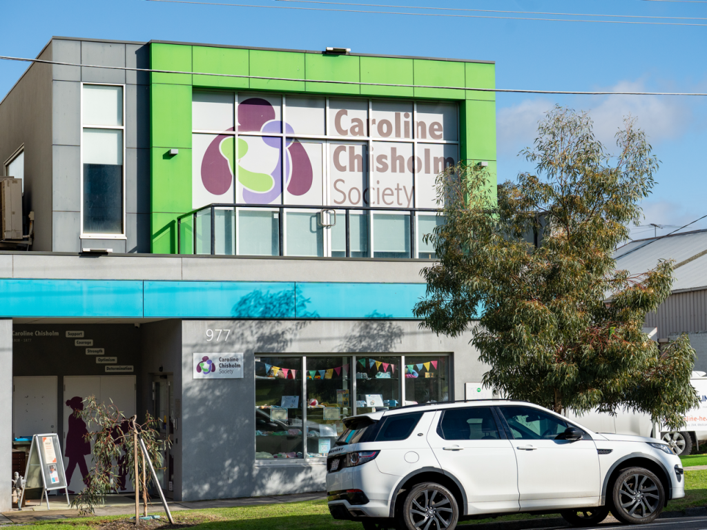 Two-storey building with grey, green and blue facing.